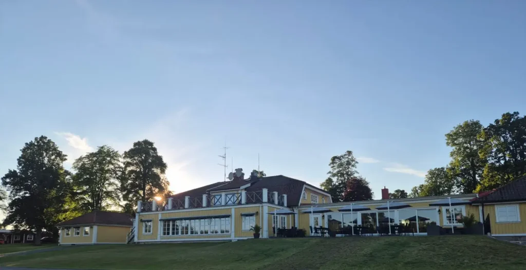 Wiredaholms fantastiska konferensanläggning sedd från gräsmattan under klar kvällshimmel.