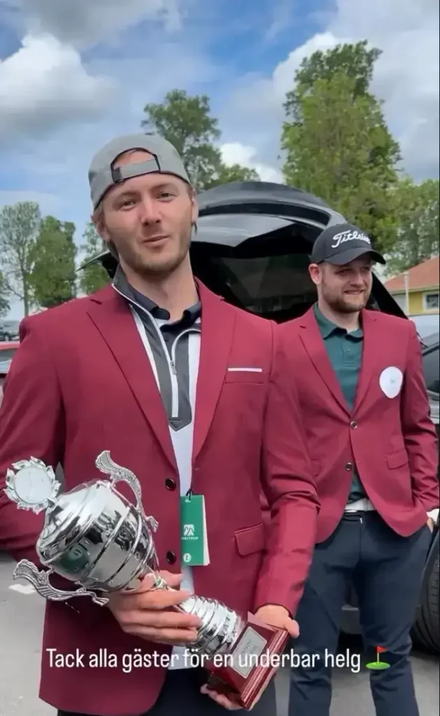 Två män efter en företagsgolf tävling på Wiredaholm, varav en håller en pokalen.